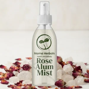 Mama Herbals Rose Alum Mist spray bottle surrounded by dried rose petals and natural alum stones.